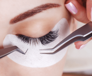A beautician is adding eyelash extensions for her client