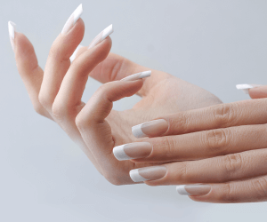 A model showing her hands with a french tip manicure.